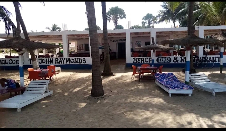 Outdoor seating and sun loungers on the sand at John Raymond's