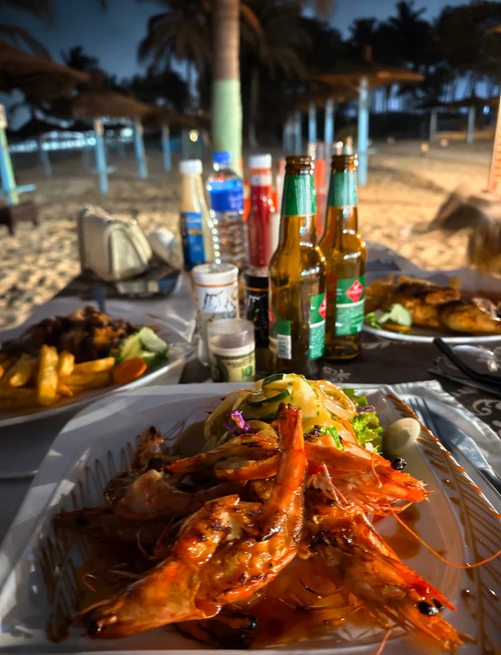 Grilled prawns and cold beer at sunset